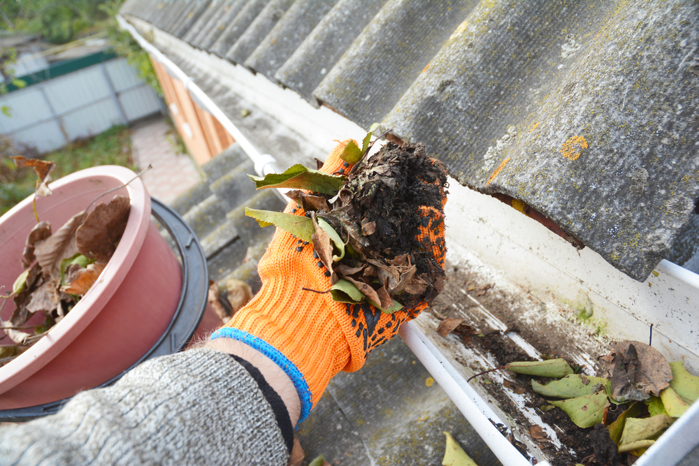 hand cleaning a gutter