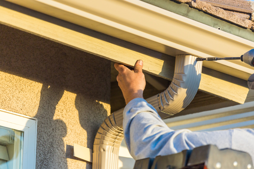 person attaching a downspout