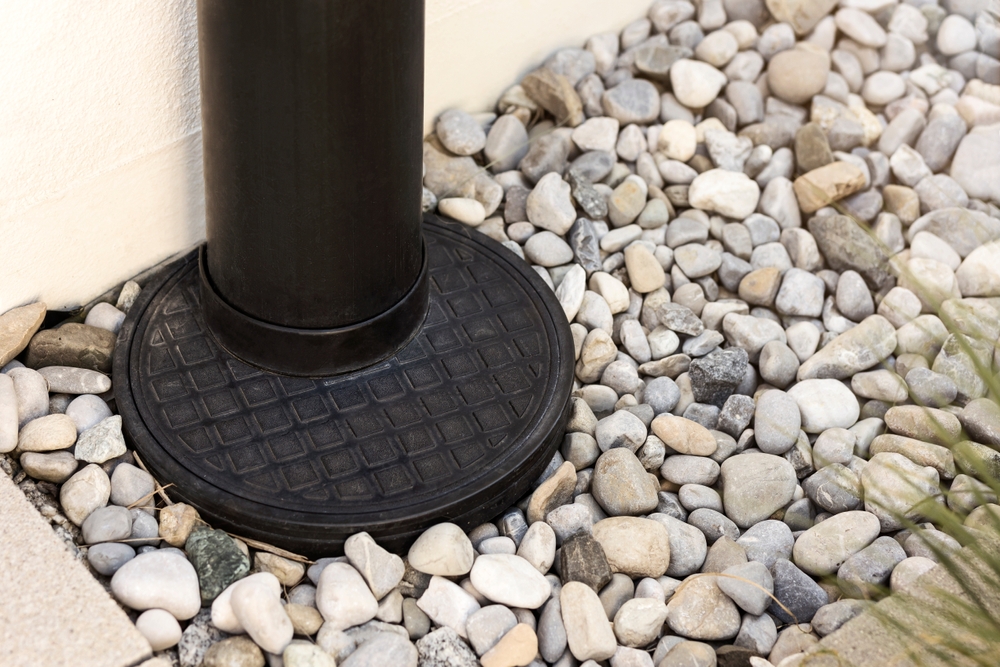 Black Drain Pipe Going Through the Floor with Stones